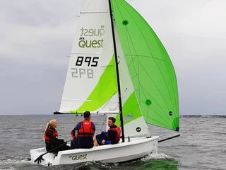 RS Quest mit drei Seglern auf dem Wasser, stabiles Trainingsboot für Einsteiger und Familien.